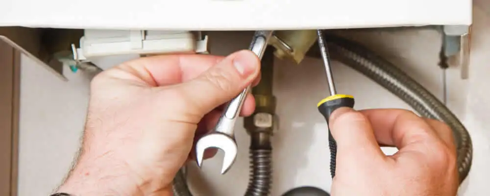 Boiler repair technician tightening pipe fittings and connections in Mountain View, CA