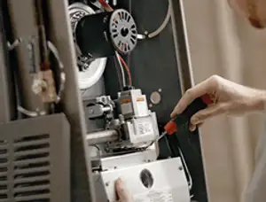 Furnace repair technician inspecting internal components and wiring in Mountain View, CA