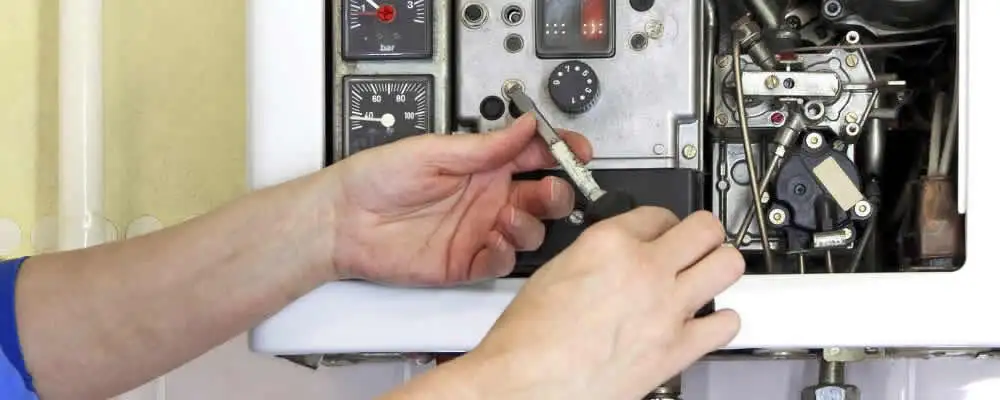 Heating repair technician adjusting boiler controls and components in Mountain View, CA