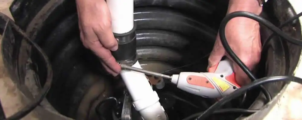 Sump pump installation technician connecting PVC discharge piping in Mountain View, CA
